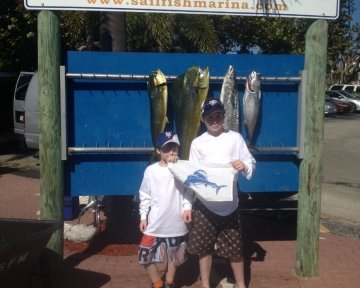 kids in front of the sailfish marina sign
